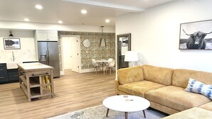 A modern living room with a sofa, a coffee table, and a rug.