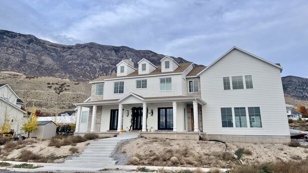 A two-story house with a front porch, a garage, and a driveway.
