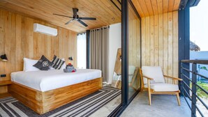 Ein modernes Schlafzimmer mit einem hölzernen Bett, einem Deckenventilator, einem großen Fenster und einem Balkon mit einem Stuhl.