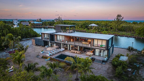 Ein modernes, mehrgeschossiges Haus mit Pool, direkt am Strand mit Blick auf den Ozean.