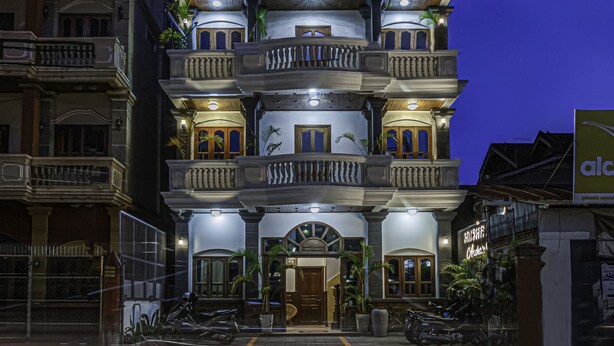 Un immeuble à plusieurs étages doté de balcons, d’une entrée principale et d’une enseigne indiquant la présence d’un restaurant.