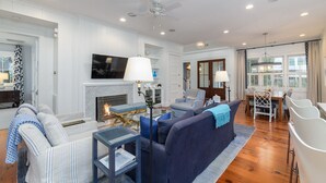 A modern living room with a fireplace, seating area, and dining space. - Charming Southern Cottage near Tennis & Golf (Bluffton)