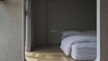 Une chambre à coucher avec un lit, une fenêtre et une porte.