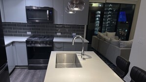 A modern kitchen with a built-in microwave, stainless steel appliances, and a white countertop. - Luxurious Condo Midtown Atlanta (Atlanta)