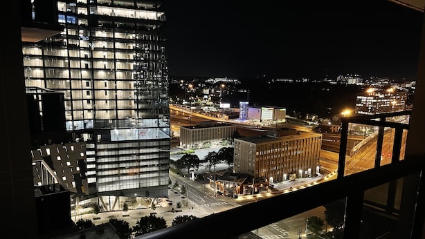 A nighttime cityscape with modern buildings, a well-lit street, and a view from a high-rise window. - Luxurious Condo Midtown Atlanta (Atlanta)