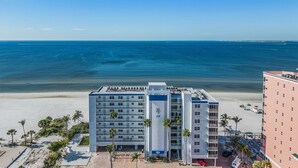 A beachfront hotel with multiple floors, a pool area, and a view of the ocean.