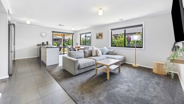 A modern living room with a sofa, coffee table, and a view of the outdoors. - Spacious Living, Lucas (Lucas)