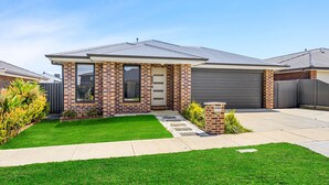A modern two-story house with a brick facade, a garage, and a well-maintained lawn. - Spacious Living, Lucas (Lucas)