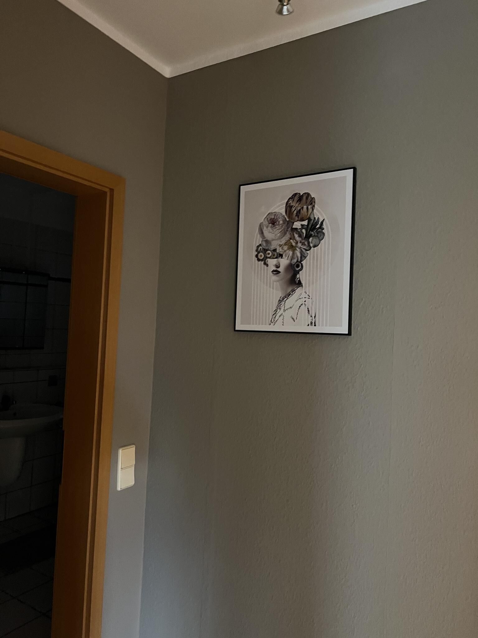 A framed artwork on a plain wall.