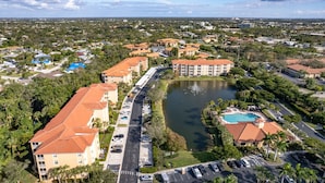 Vue aérienne d’un quartier résidentiel comprenant un grand ensemble d’immeubles, une piscine et un lac.