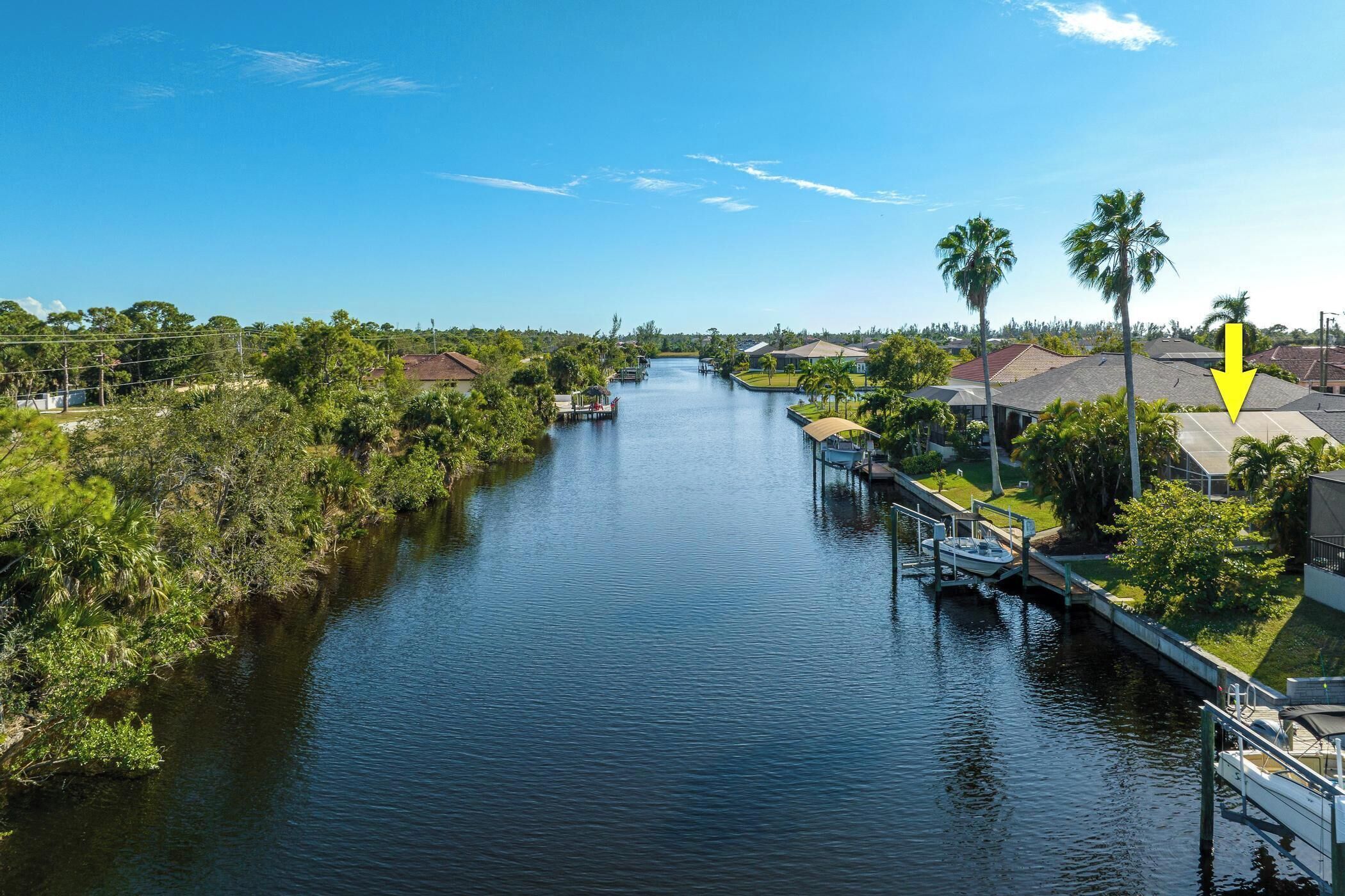 A river with houses on one side and a dock with a boat.