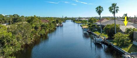 A river with houses on one side and a dock with a boat.