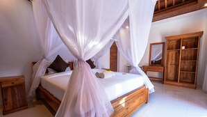 Un dormitorio espacioso con una cama grande, cabecero de madera y dosel. Hay un armario de madera y una mesita de noche con lámpara.