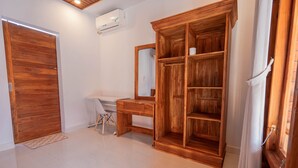 Una habitación con un armario de madera, un escritorio, una silla y un espejo.