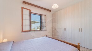 Un dormitorio con cama, ventana y armario.