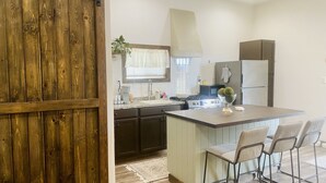 A kitchen with a central island, dark cabinets, and a sliding barn-style door. - A clean, comfortable space just off the interstate with easy parking. (Worden)