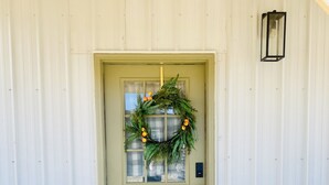 A green door with a wreath, a welcome mat, and a light fixture above. - A clean, comfortable space just off the interstate with easy parking. (Worden)
