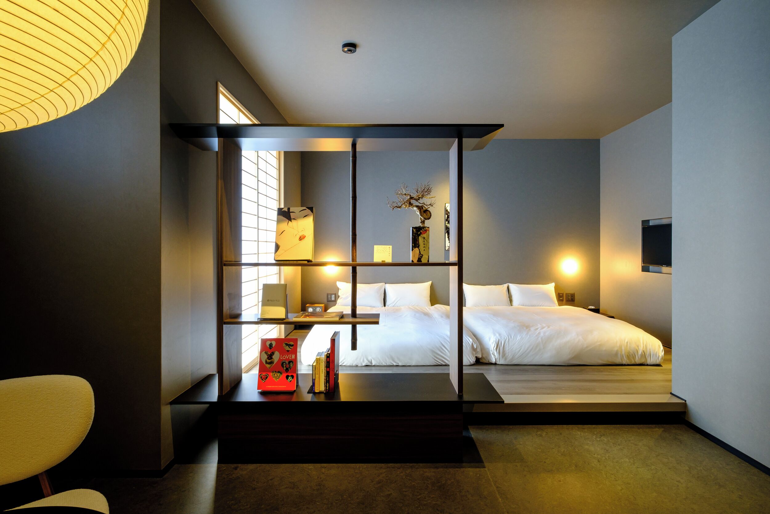 Un dormitorio moderno con cama, mesitas de noche, un escritorio y una silla.