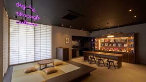 Um interior moderno com esteiras de tatame, uma mesa de jantar de madeira e uma estante.