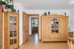 Ein Holzkabinent mit Glastüren, ein Holztisch und eine Pflanze.