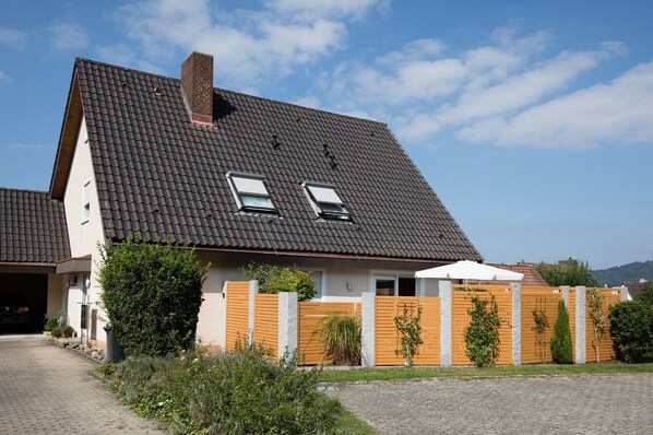 A two-story house with a sloped roof, a chimney, and two skylights.