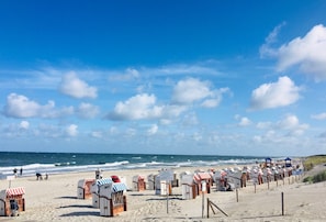 Una spiaggia con file di cabine e un cielo sereno.