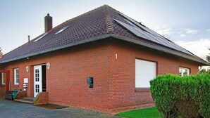 A red brick building with a sloped roof, a chimney, and a white garage door.