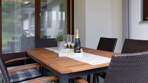 Une table de salle à manger en bois, avec une bouteille de champagne, deux verres et un menu.