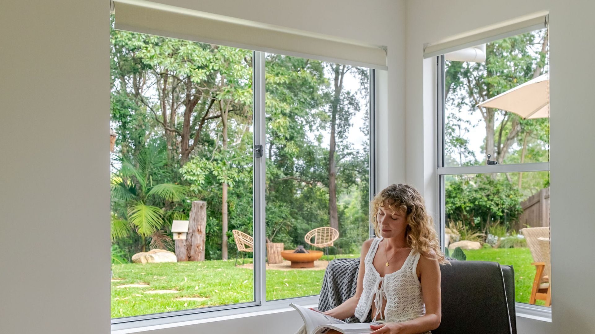 Una habitación con ventanas amplias, una silla y una mesa.