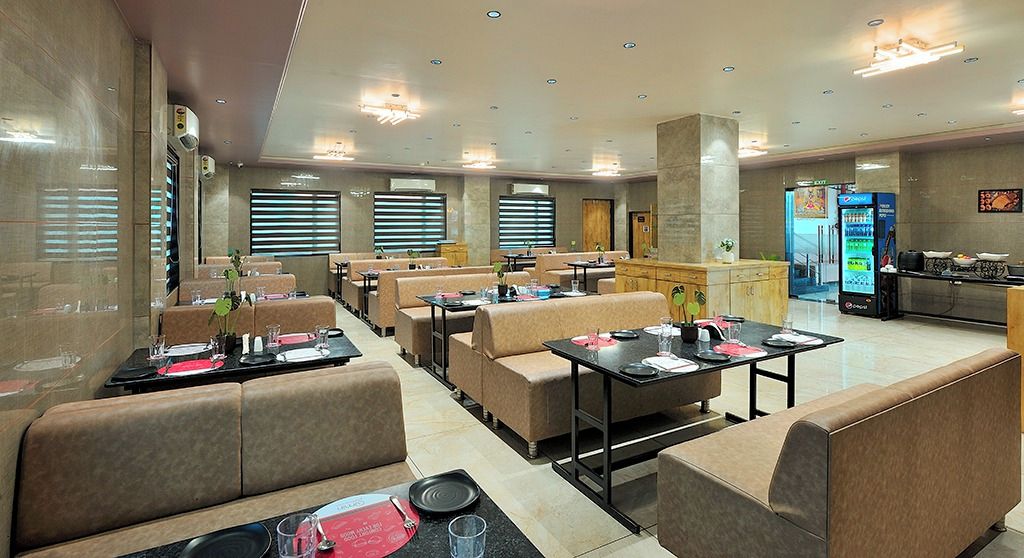 A restaurant with booths and tables, a vending machine, and a counter.