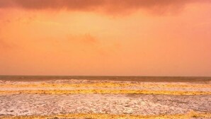 Una playa con olas y un cielo nublado.