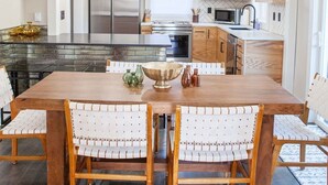 A modern kitchen with a central island, stainless steel appliances, and wooden cabinetry. - Updated Campus Home (Eugene)