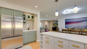 A modern kitchen with stainless steel appliances, light green cabinets, and a white countertop. - Saulsbury Guest House & Wellness Retreat w/ Sauna (Wheat Ridge)