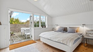 A bedroom with a large bed, a wooden floor, a white ceiling, a window, and a view of the outside. - Gorgeous home in Assens with kitchen (Assens)