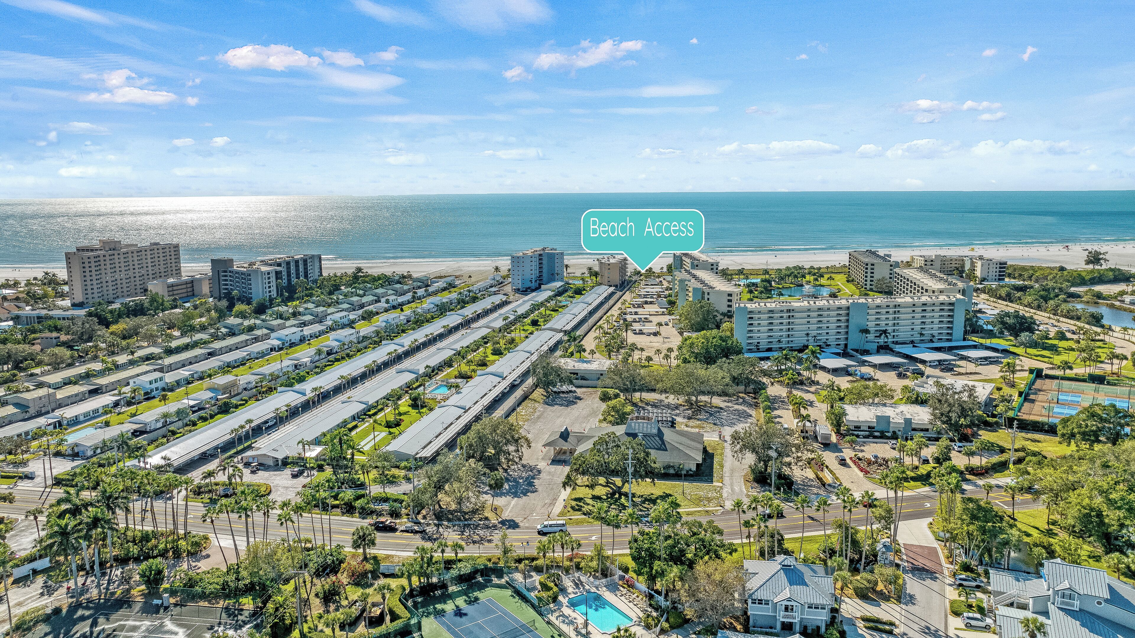 A resort with multiple buildings, a beach, and a pool area.