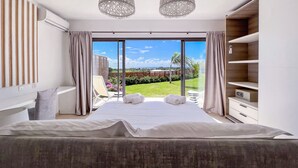 Een moderne slaapkamer met een groot bed, een balkon met uitzicht en een inbouwkast.