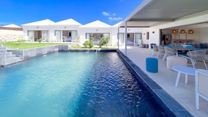 Een modern resort met een zwembad, terras en meerdere gastenkamers.