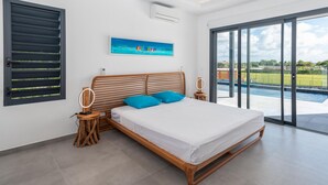 Une chambre moderne avec un lit en bois, une vue sur une piscine et un tableau accroché au mur.