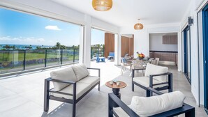 Un salon moderne doté d’un grand balcon, d’un coin repas et d’une cuisine.