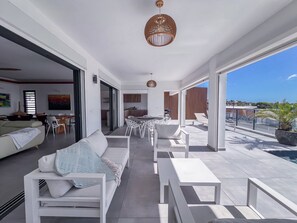 Un salon moderne avec un canapé, une table à manger et des chaises, une cuisine en arrière-plan et un balcon avec vue.