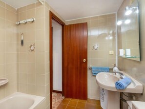 Une salle de bain avec une baignoire, un lavabo et un miroir.