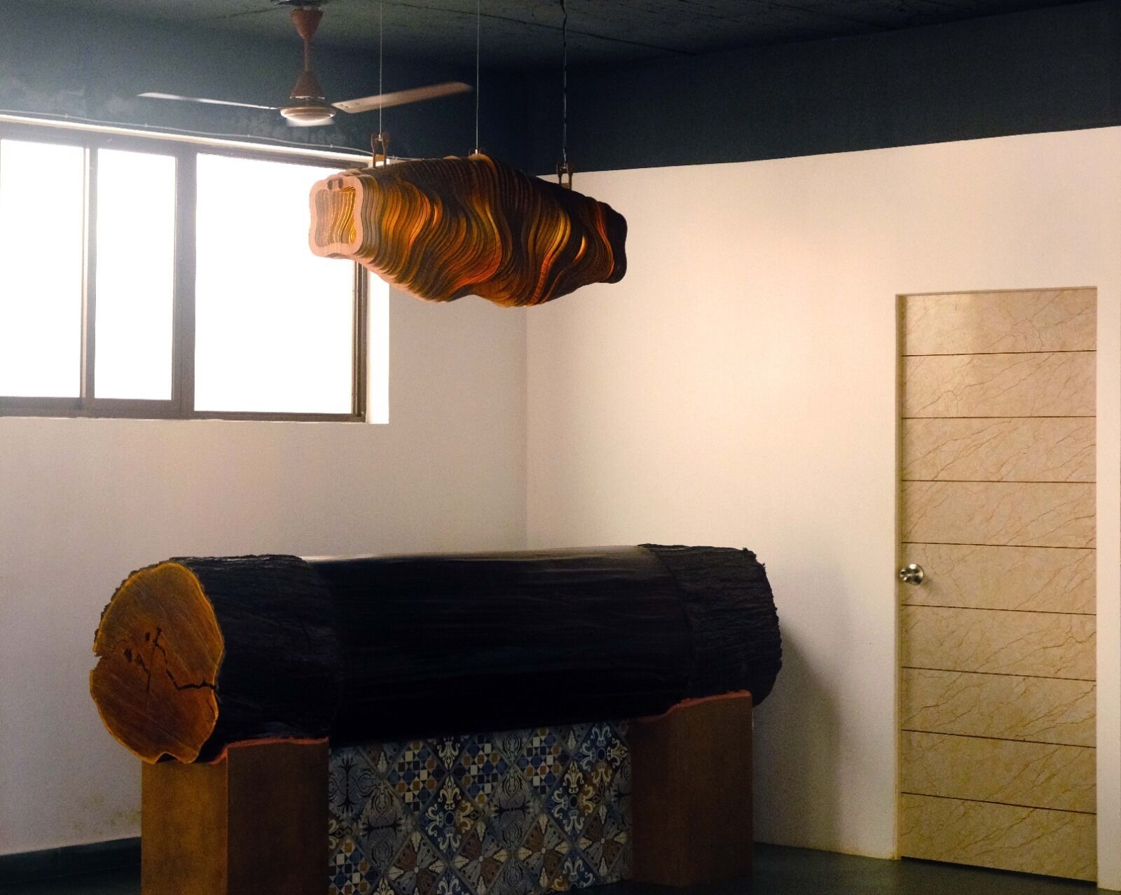 A room with a bed, a wooden door, and a window.