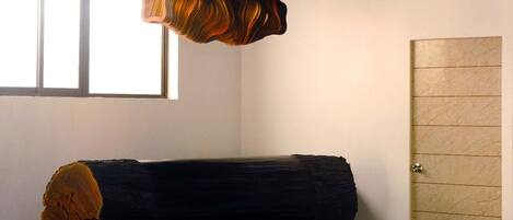 A room with a bed, a wooden door, and a window.