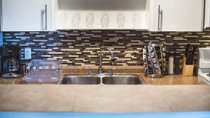 A modern kitchen with a double sink, a coffee maker, a dish rack, and a knife block. - Montrose Relaxing Studio! Medical Center 37 (Houston)