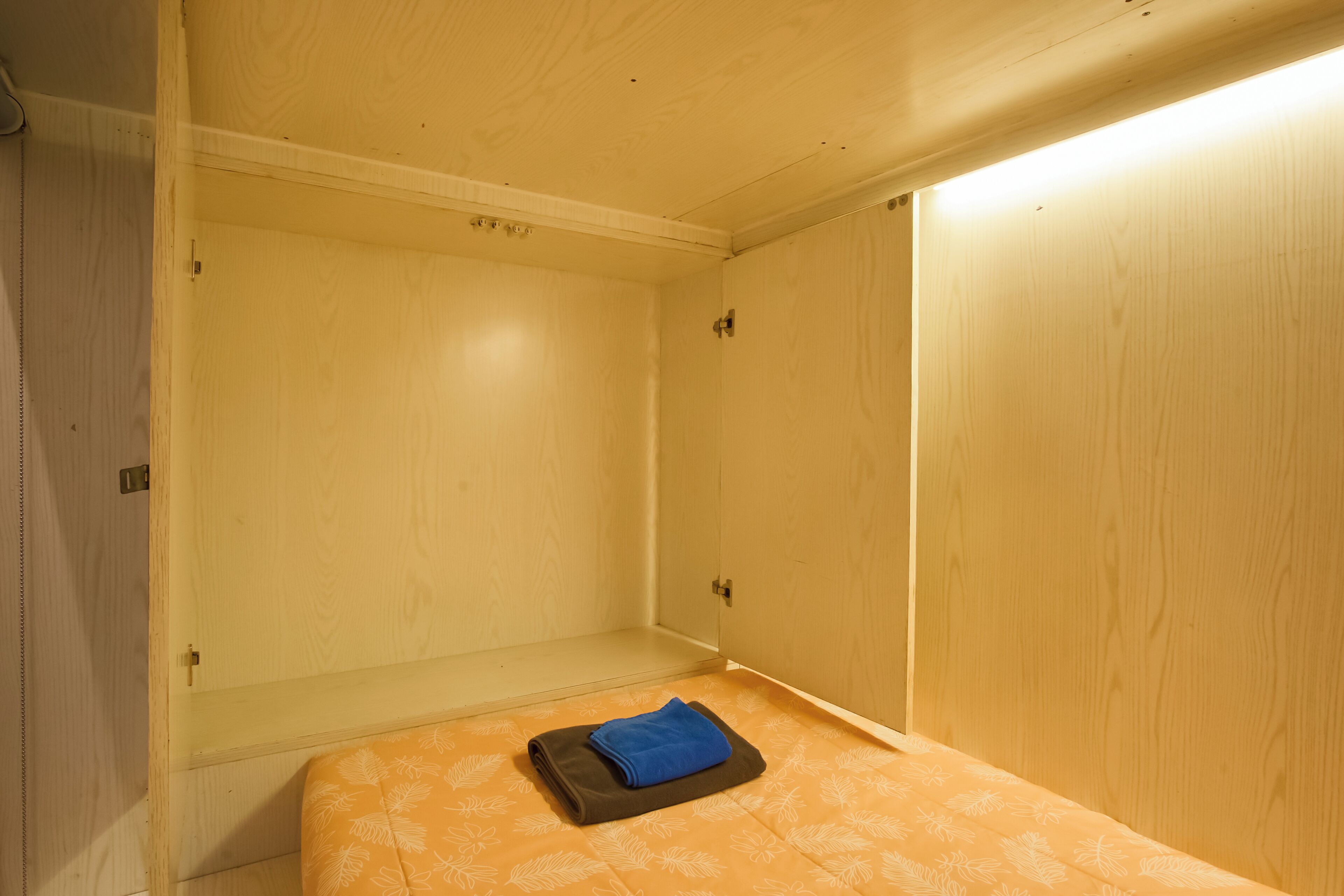 A bedroom with a bed, a wardrobe, and a small table.