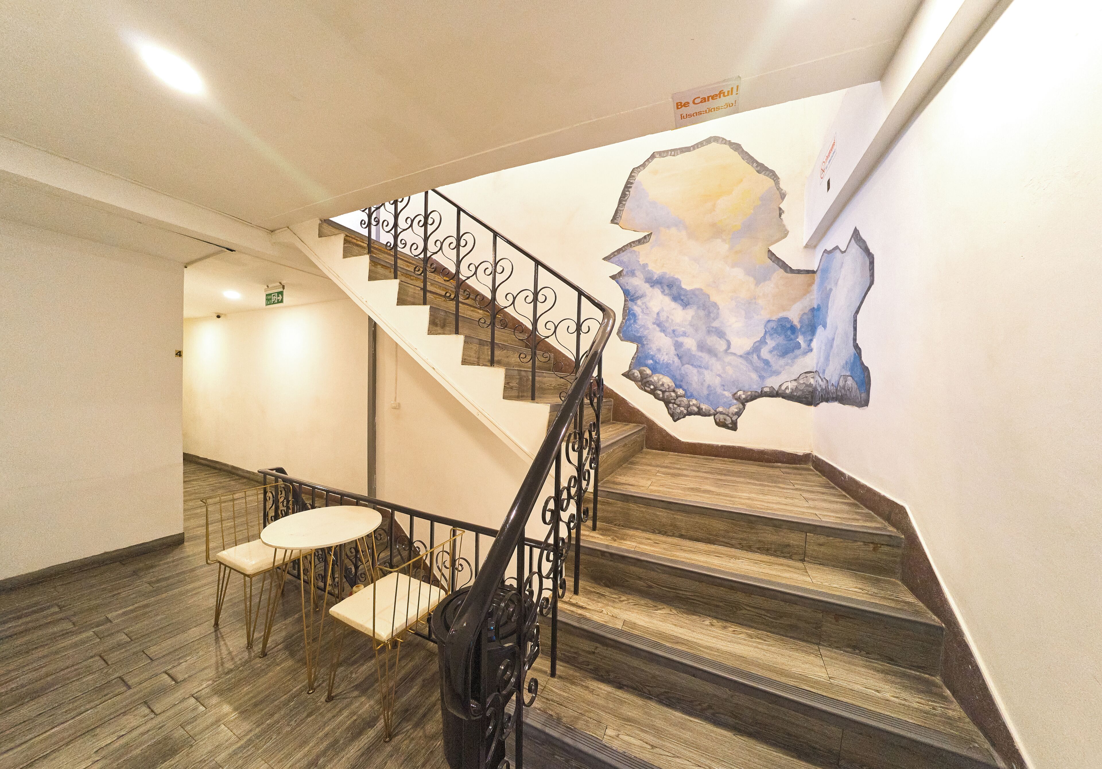 A staircase with a wooden finish and metal railings, leading to an upper floor.