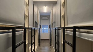 A corridor with bunk beds, wooden flooring, and a ceiling light. - comfy crib hostel  (Bangkok)