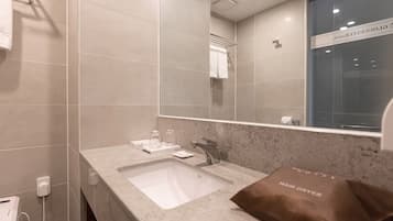 A modern bathroom with a large mirror, a sink, and a towel rack.