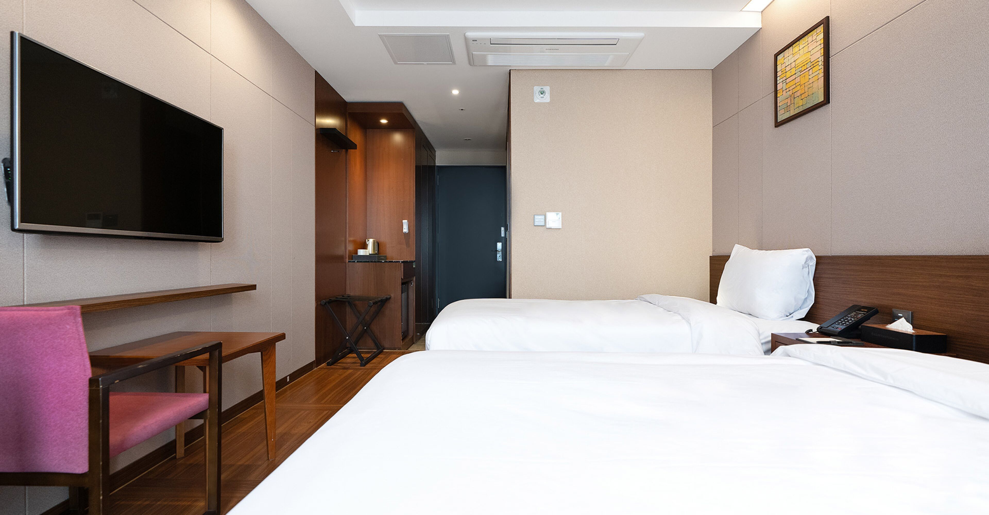 Habitació d'hotel amb llit, escriptori, cadira, televisió i telèfon.