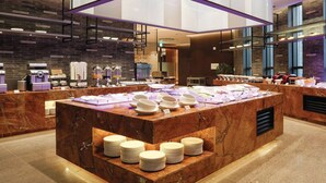 A buffet setup with a marble counter, plates, and various food items. - Gloucesterhotel Jeonju  (Jeonju)